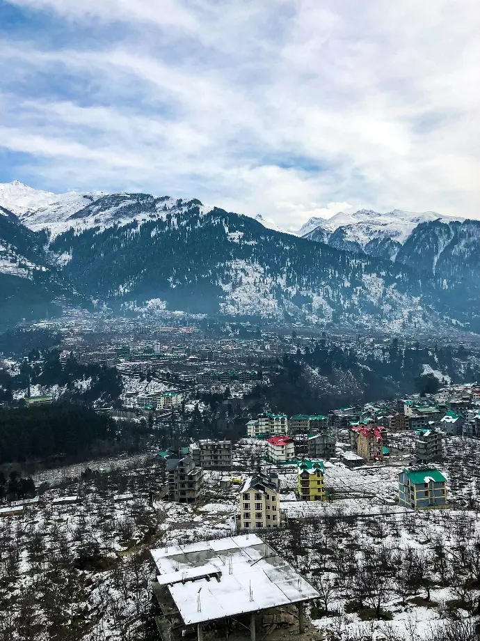 aerial view of city near snow covered mountains during daytime